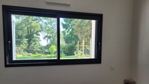 A room with a large window overlooking a garden.