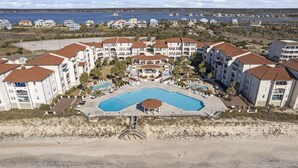 Ein Resort mit mehreren Gebäuden, einem zentralen Pool und einem Strandabschnitt.