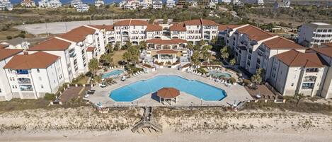 Ein Resort mit mehreren Gebäuden, einem zentralen Pool und einem Strandabschnitt.