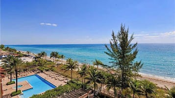 Enjoy ocean views from the resort's pool and lounge areas surrounded by palm trees.