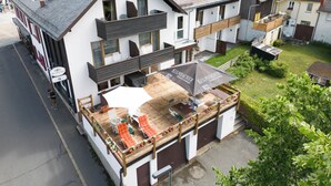 Un bâtiment à deux étages doté d’un balcon, d’une terrasse et d’une enseigne indiquant « KULMACHER ».