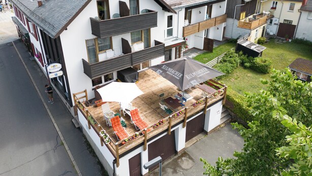 Un bâtiment à deux étages doté d’un balcon, d’une terrasse et d’une enseigne indiquant « KULMACHER ».