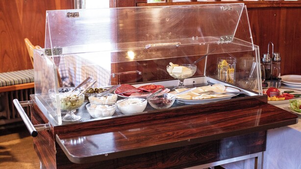 Un buffet proposant une variété de plats et une vitrine réfrigérée.
