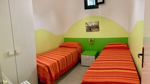 A room with two beds, a green nightstand, a white cabinet, and a picture on the wall. - "LE SORELLE" holiday home with sea view Santa Maria al Bagno 100 meters from the beach (Nardò)