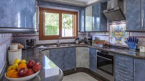 A modern kitchen with grey cabinets, a built-in oven, and a window providing natural light.
