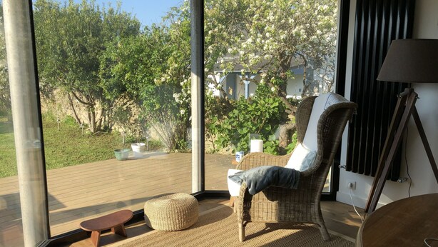 A modern living room with a large glass door leading to an outdoor patio. - Rental House Quiberon 6 beds (Quiberon)