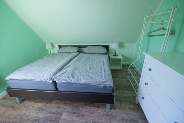 A room with a bed, bedside tables, and a dresser. - Lovingly furnished, cozy cottage in country style. (Oybin)