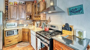 Une cuisine dotée de meubles en bois, d’une cuisinière, d’un four à micro-ondes et de divers appareils de cuisine.