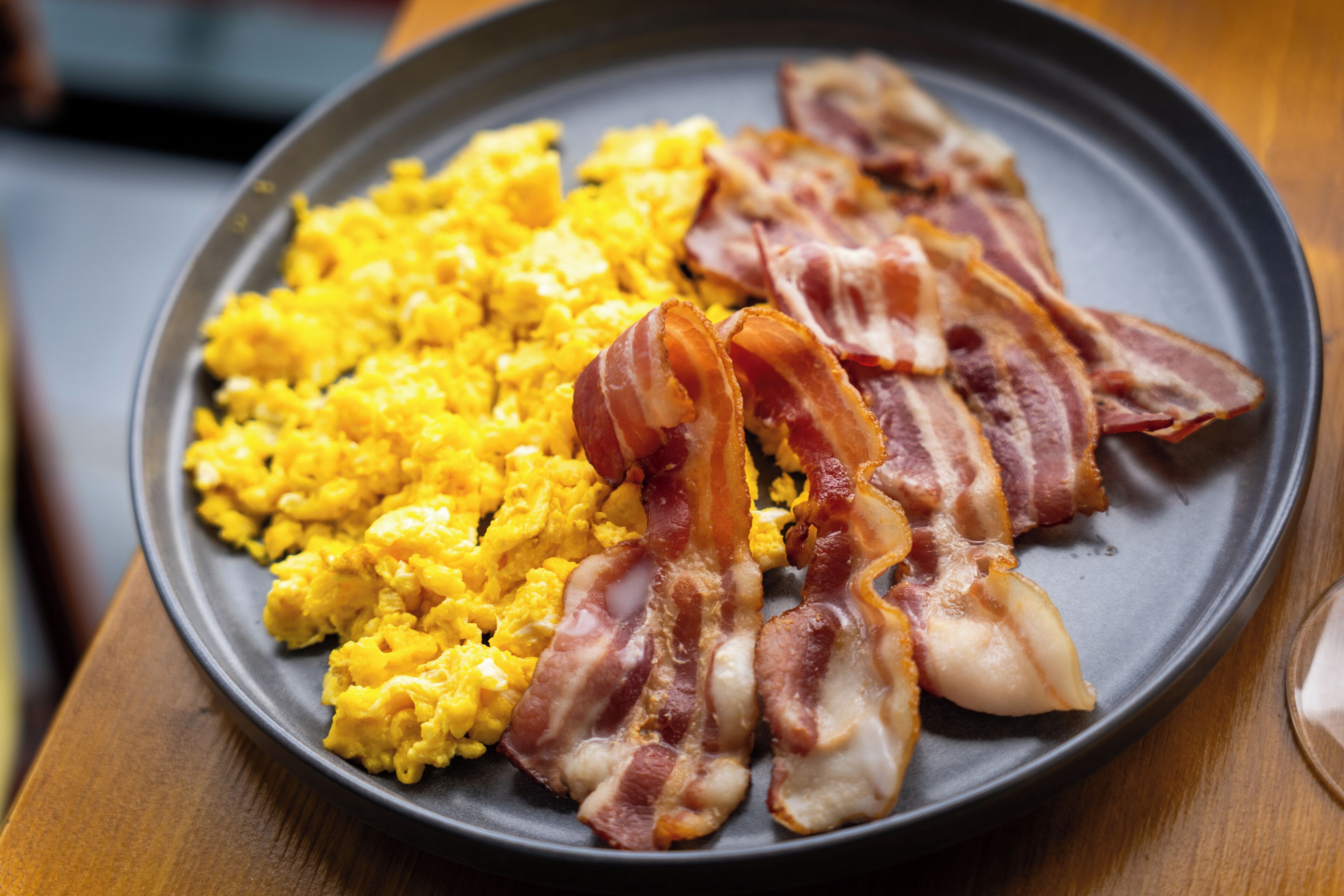 Des œufs brouillés et des lardons servis dans une assiette.