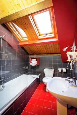 A bathroom with a skylight, a bathtub, a toilet, and a sink. - Hotel A. G. Porcillán (Ribadeo)
