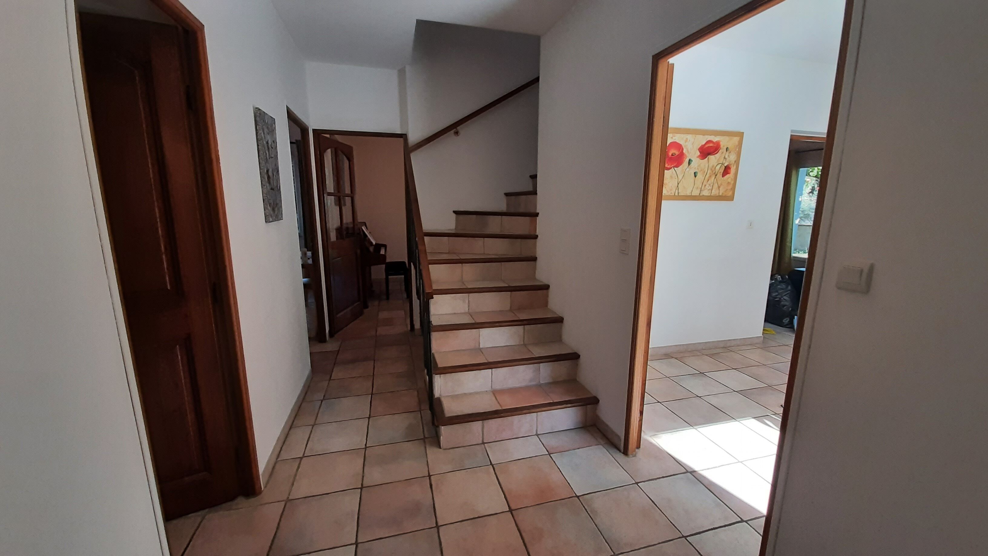 A staircase with a wooden handrail leading to an upper floor.