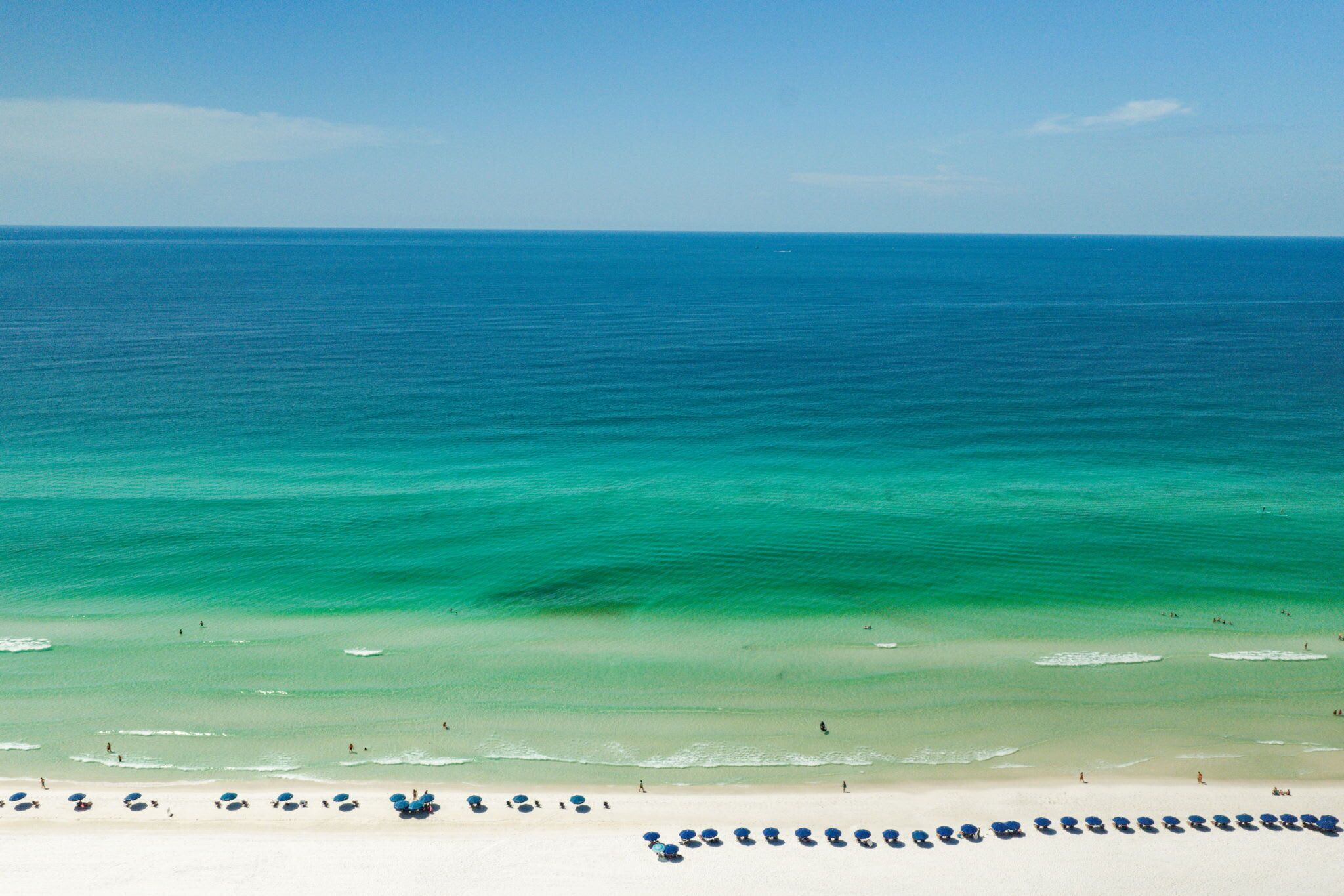 Ein Strand mit klarem türkisblauem Wasser und einem Sandstrand.