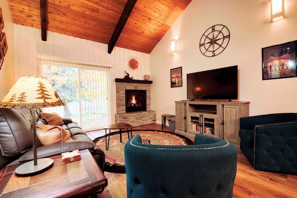 Living room with smart TV, gas fireplace leads to back patio.