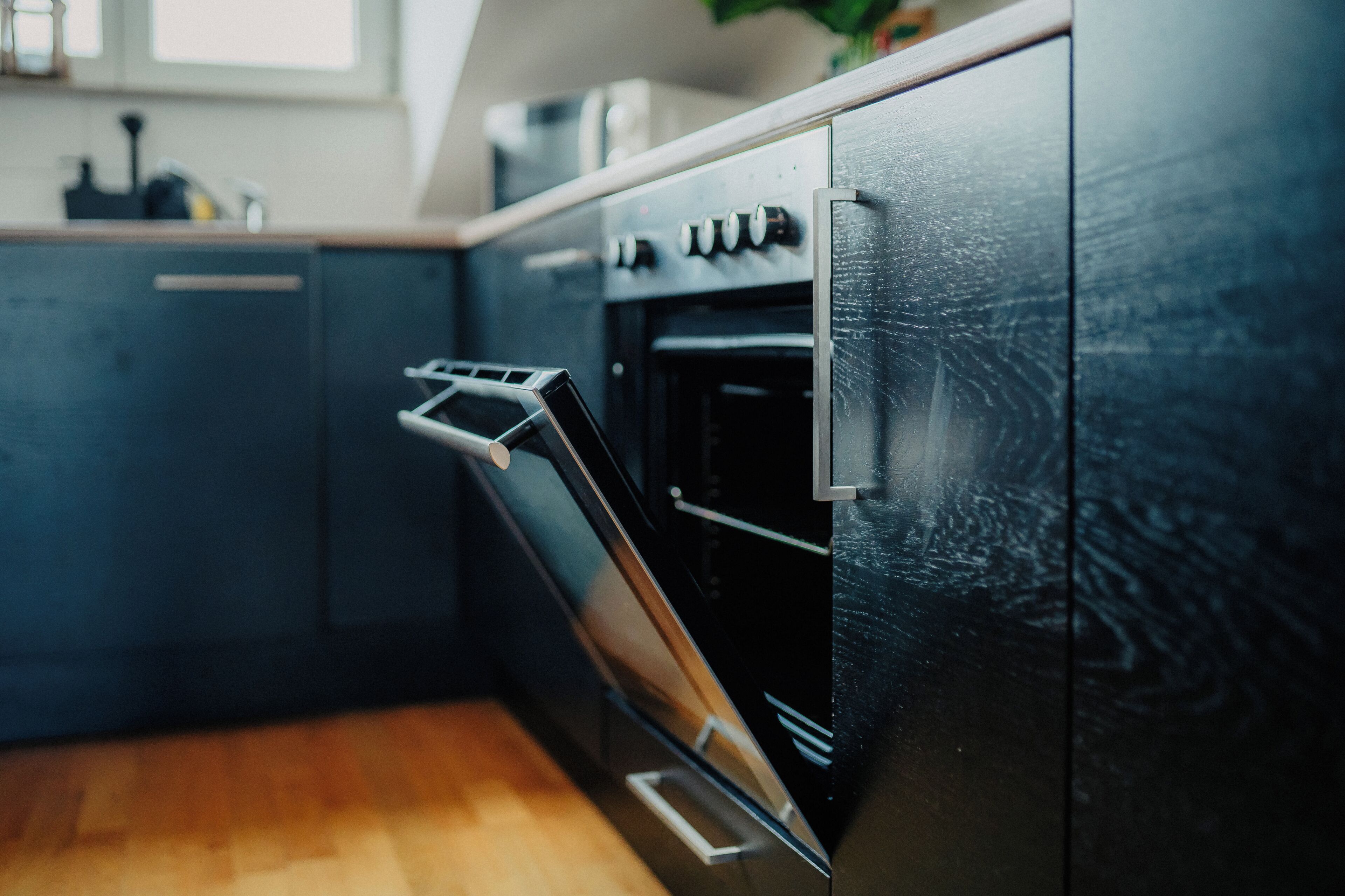 Una cocina moderna con horno empotrado y extractor de acero inoxidable.