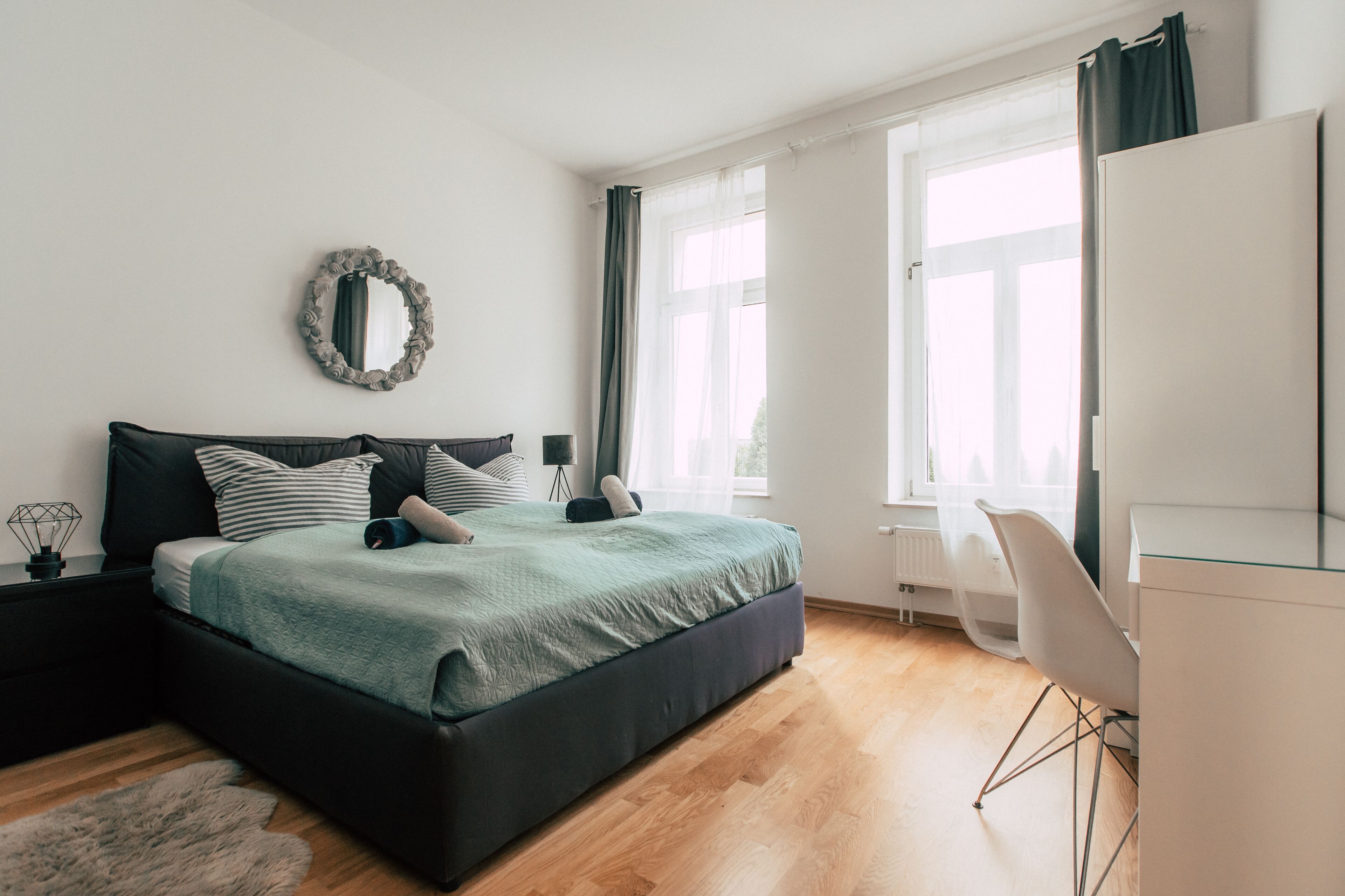 Un dormitorio moderno con una cama grande, un escritorio y una silla.
