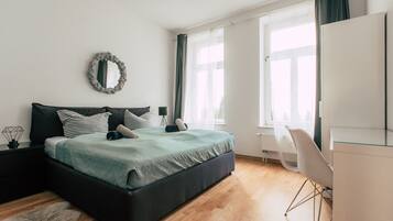 Un dormitorio moderno con una cama grande, un escritorio y una silla.