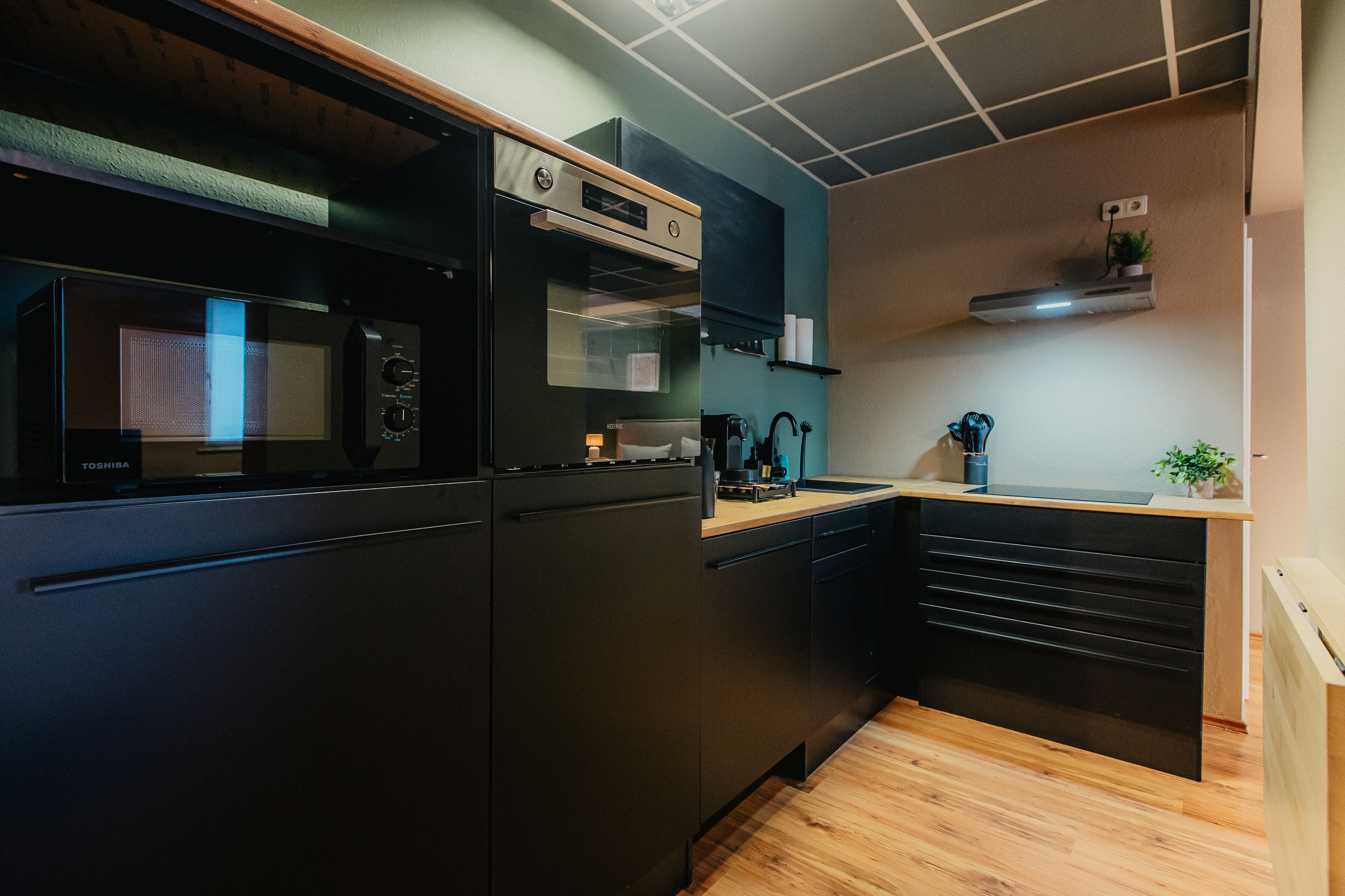 A compact kitchen with a microwave, oven, and built-in cabinets.