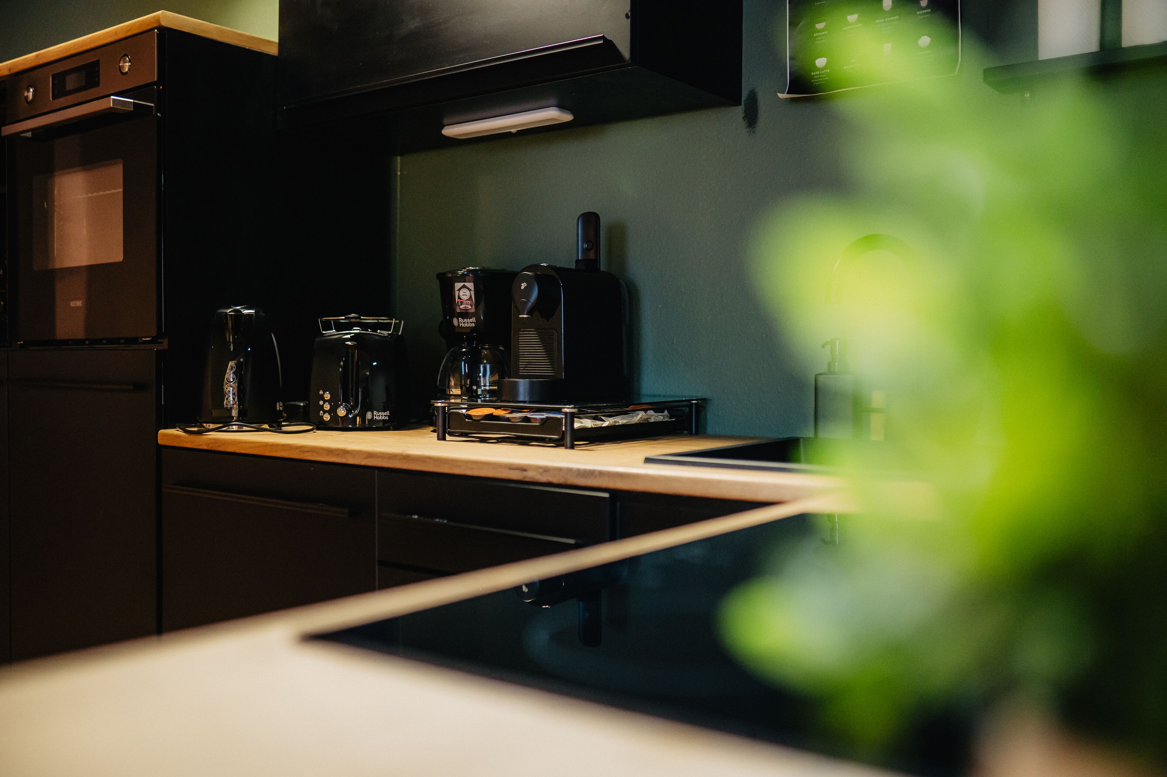 Una cocina con cafetera, tostadora y microondas.