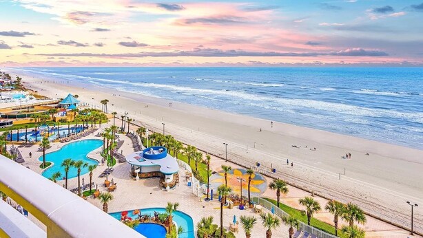 Un resort con piscina, acceso a la playa y vistas al océano.
