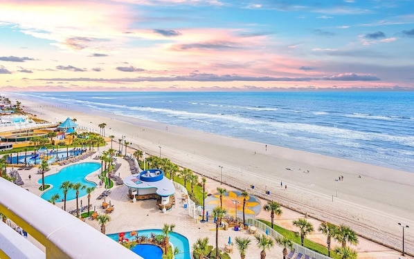 A resort with a pool area, beach access, and a view of the ocean.
