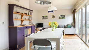 Eine moderne Küche mit Esstisch, Stühlen und einem Fernseher.