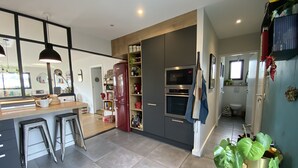 A modern kitchen with a central island, built-in appliances, and a view into the dining area.