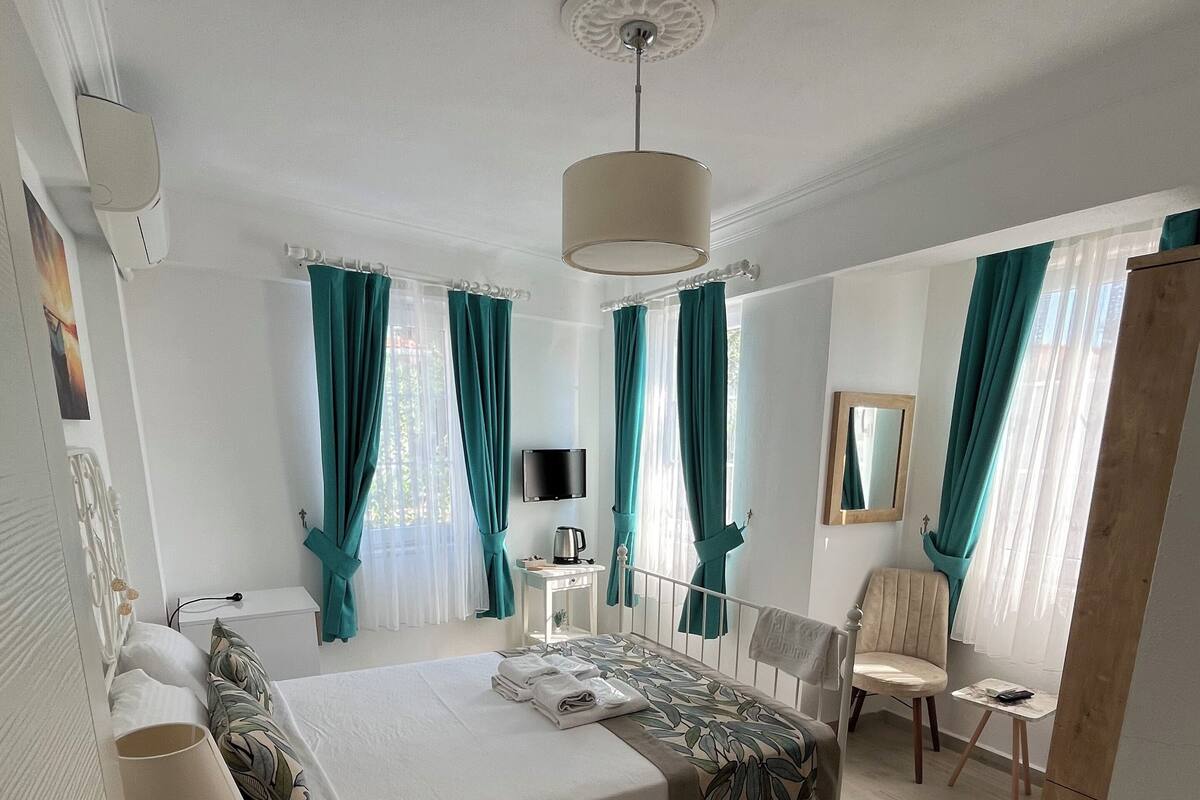 Une chambre moderne avec un lit, une table de chevet et un petit bureau avec une chaise.