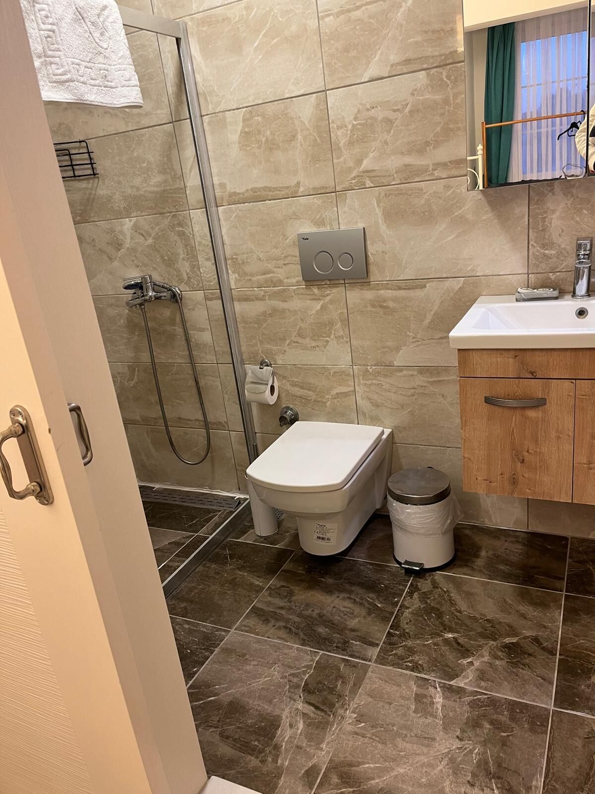 A bathroom with a shower, toilet, and sink.