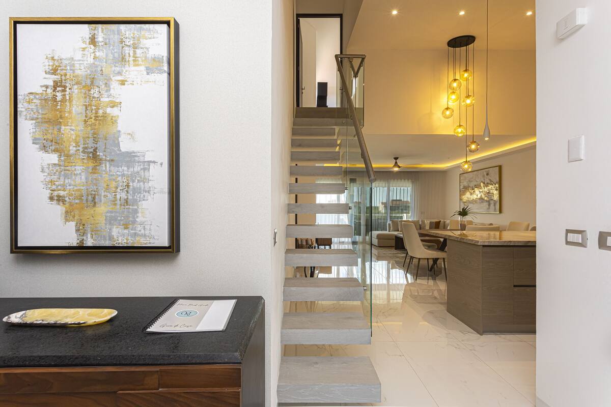 A modern interior with a staircase, a dining area, and a kitchen.