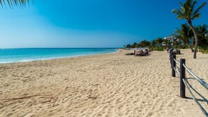 A beach with a clear blue sky, sandy shore, and palm trees. - Mareazul Beach Condos Playa Del Carmen (Playa del Carmen)
