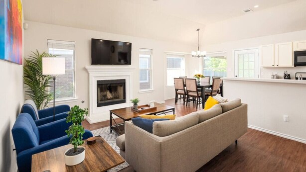 A living room with a fireplace, a sofa, a coffee table, and a TV.