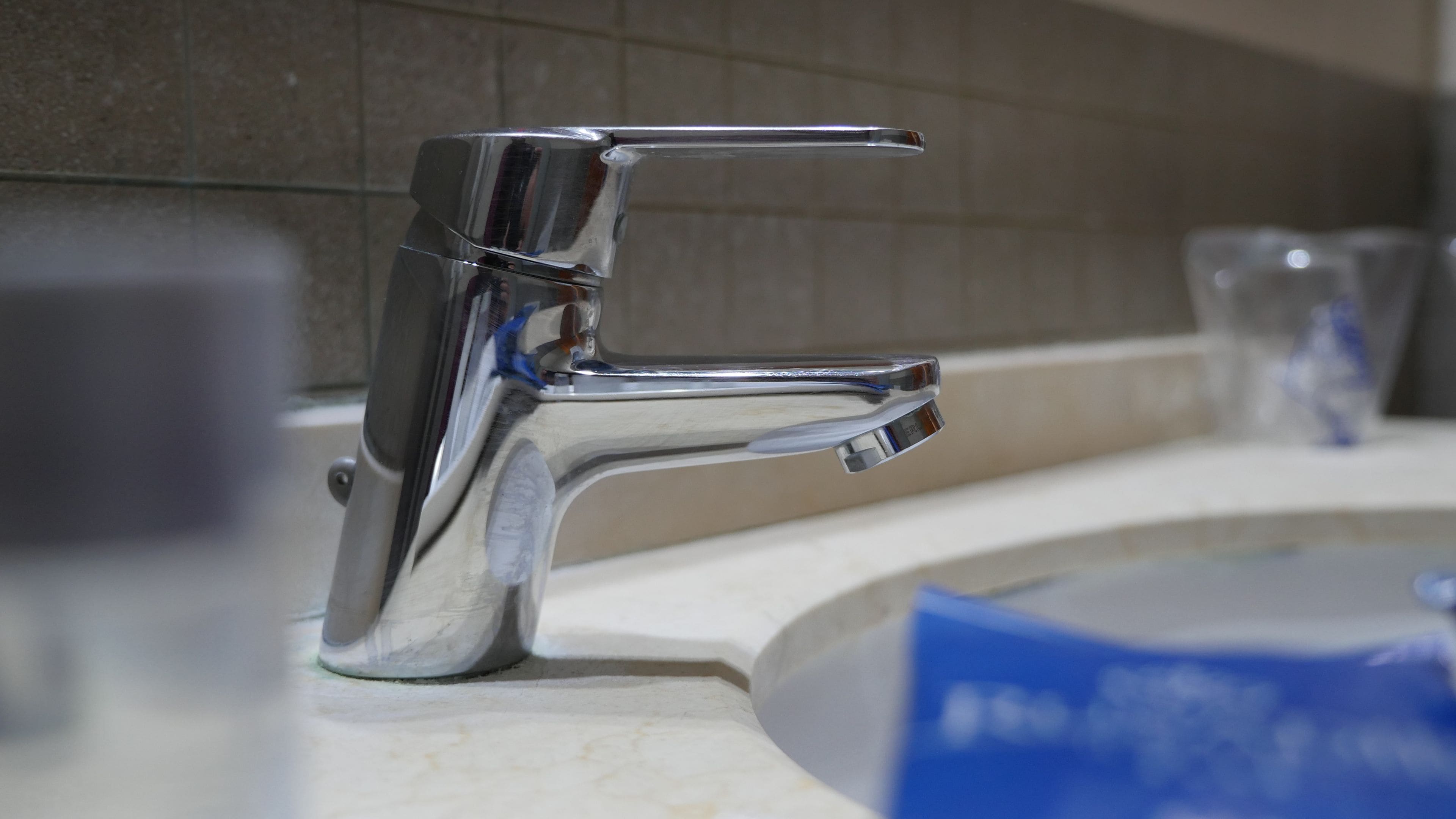 Un grifo cromado con una sola palanca sobre un lavabo de baño.
