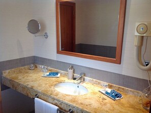 A bathroom with a marble sink, two faucets, a mirror, and a towel rack. - Rusadir (Melilla)