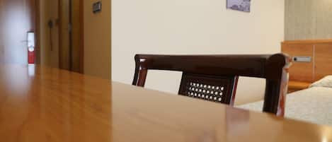 A wooden dining table with a chair in front.