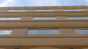 A multi-story building with a beige facade and rectangular windows. - Rusadir (Melilla)