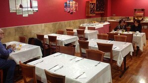 A dining area with multiple tables, chairs, and a buffet setup. - Rusadir (Melilla)