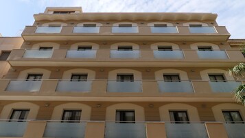 Un edificio de varios pisos con balcones y ventanas arqueadas.