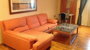 Un soggiorno con un divano, un tavolino da caffè e un quadro appeso al muro.