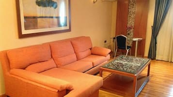 Una sala de estar con un sofá, una mesa de centro y un cuadro en la pared.