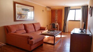 Ein Wohnzimmer mit einer Couch, einem Couchtisch und einer TV-Konsole.