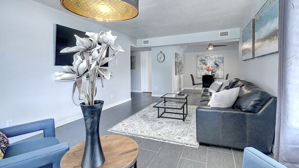 A modern living room with a sofa, coffee table, and a decorative plant.