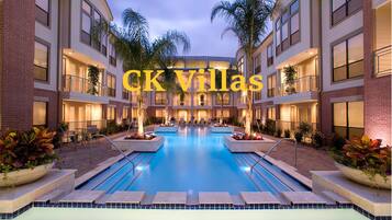 CK Villas offers a central swimming pool surrounded by lush landscaping and palm trees.