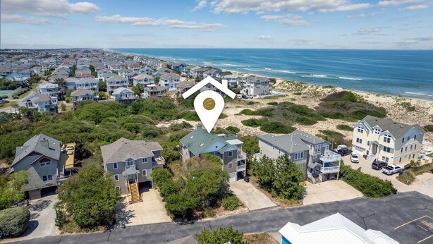 Une zone résidentielle côtière avec des maisons, une plage et un ciel dégagé.