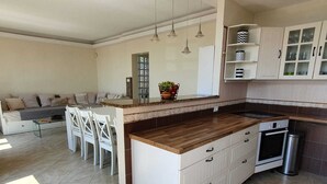 A modern kitchen with a wooden countertop, white cabinetry, and a built-in oven.