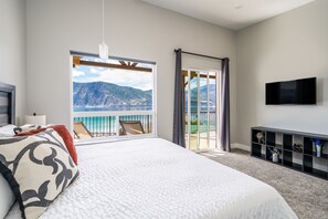 Enjoy a serene mountain view from the comfort of this stylish room, featuring a large bed and a flat-screen TV.