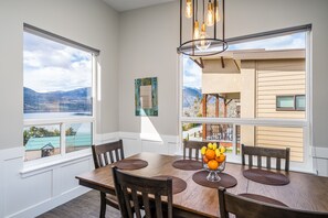 Enjoy meals with a view of the surrounding mountains and water from this dining area, featuring a large table and comfortable seating for six.