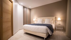 Une chambre moderne avec un grand lit, deux lampes de chevet et une porte en bois.