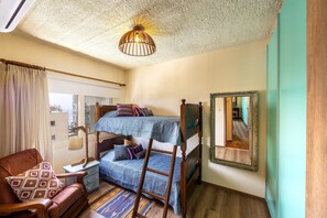 A bedroom with a bunk bed, a wooden ladder, a chair, a bedside table, and a mirror on the wall. - CASA FELIZ TWO BEDROOM A406 (Germasogeia)