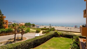 A coastal view with a beach, a road, and residential buildings.