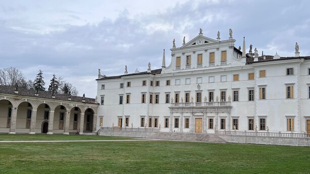 A large, white building with multiple windows and statues on the roof. - Mi-Re-La House in the vicinity of historic Villa Manin - Codroipo (CODROIPO)